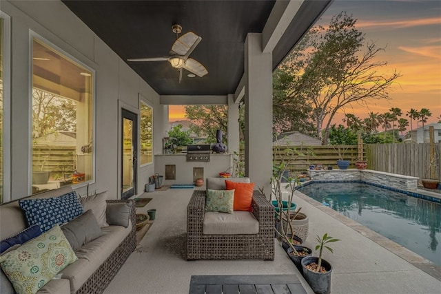 pool at dusk with a fenced in pool, ceiling fan, an outdoor kitchen, an outdoor living space, and a fenced backyard