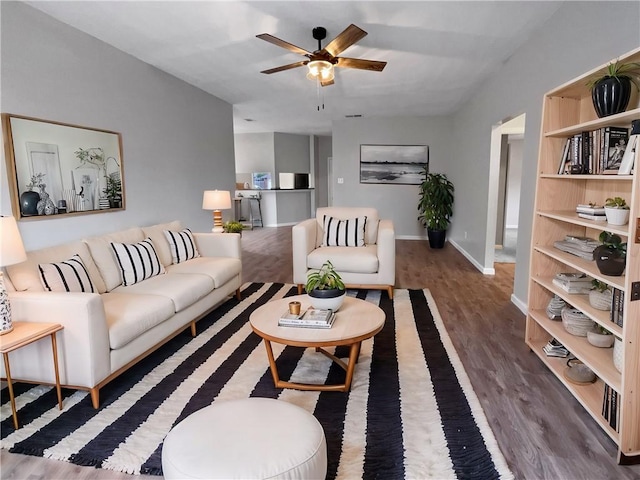 living room with dark wood-type flooring and ceiling fan