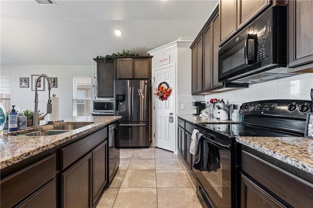 kitchen with black appliances, light tile patterned floors, sink, light stone countertops, and dark brown cabinets