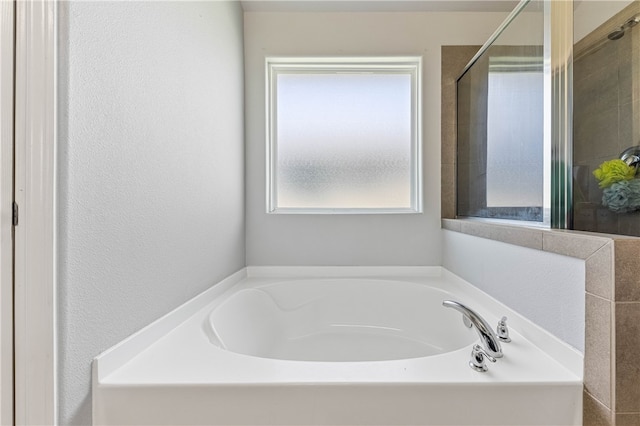 bathroom featuring a wealth of natural light and shower with separate bathtub