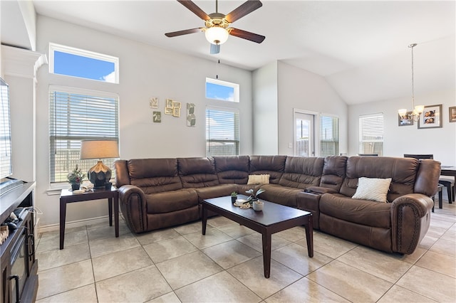 tiled living room featuring a wealth of natural light, lofted ceiling, and ceiling fan with notable chandelier