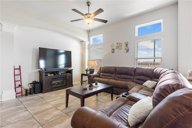 living room with a fireplace, ceiling fan, a healthy amount of sunlight, and light tile patterned floors