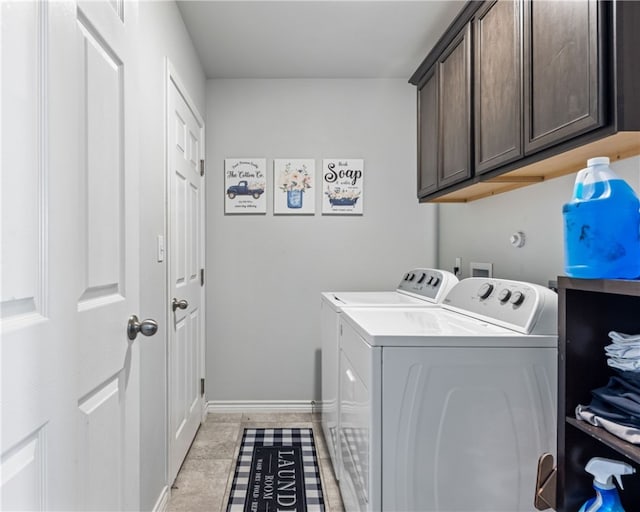 washroom featuring cabinets, washing machine and dryer, and light tile patterned flooring