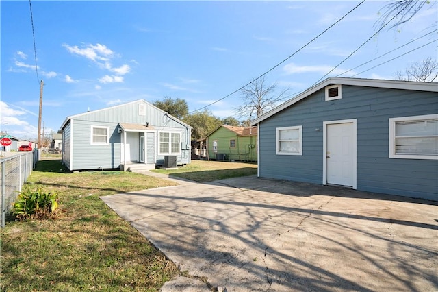 view of outdoor structure featuring entry steps, driveway, fence, and cooling unit