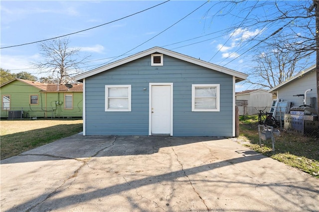 view of outbuilding featuring driveway, central AC unit, and fence