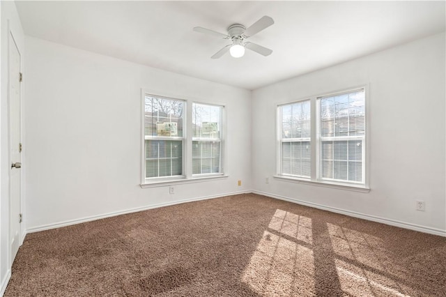 empty room with carpet flooring, a ceiling fan, and baseboards