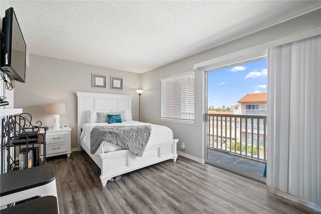 bedroom with access to outside, dark hardwood / wood-style flooring, and a textured ceiling