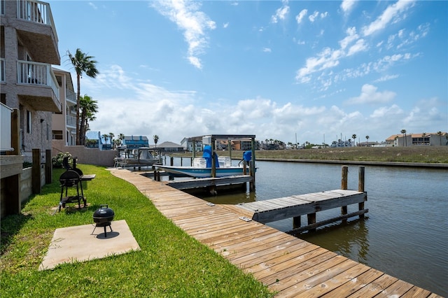 view of dock with a water view and a yard