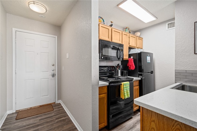 kitchen with light brown cabinetry, tasteful backsplash, black appliances, and light hardwood / wood-style flooring