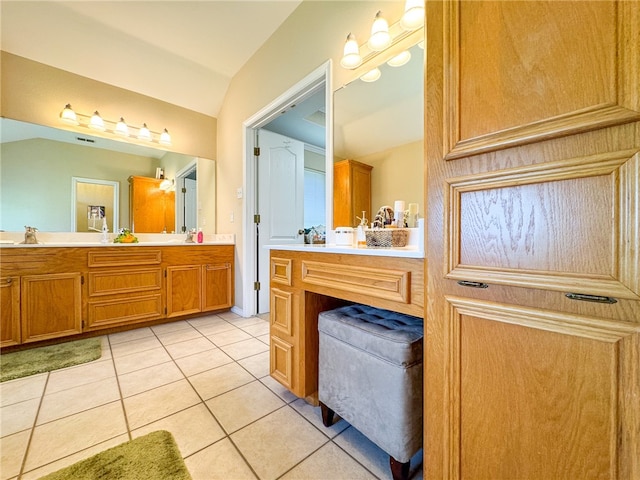 bathroom with vanity, vaulted ceiling, and tile patterned floors