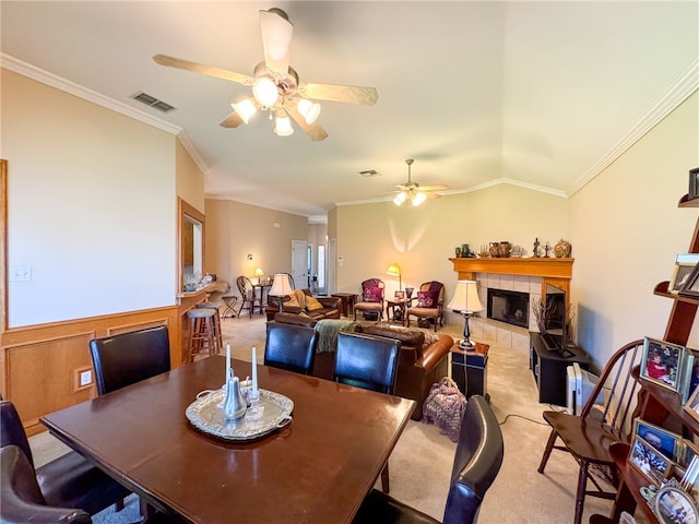 carpeted dining space featuring ceiling fan, ornamental molding, and a fireplace