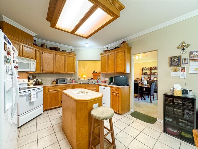 kitchen with a center island, decorative backsplash, light tile patterned floors, crown molding, and white appliances