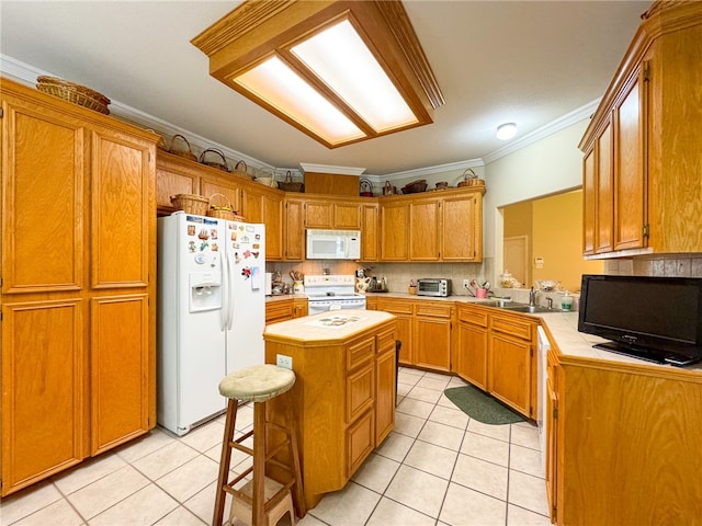 kitchen featuring crown molding, backsplash, a kitchen breakfast bar, white appliances, and a center island