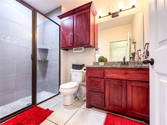 bathroom with toilet, vanity, tile patterned floors, and walk in shower