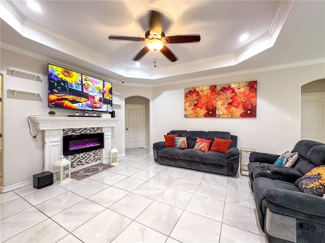 living room featuring ornamental molding, ceiling fan, a raised ceiling, and light tile patterned floors