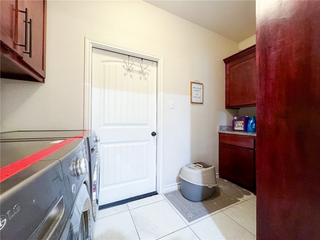 laundry area featuring light tile patterned flooring, cabinets, and washer and dryer