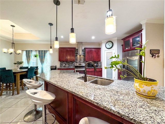 kitchen with wall chimney range hood, sink, and crown molding