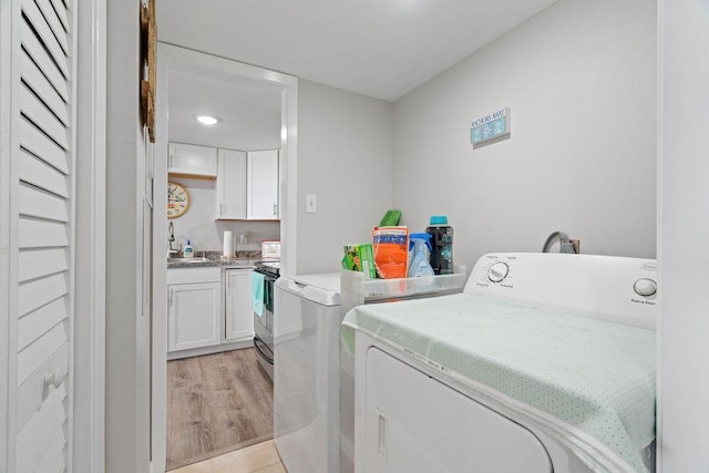 washroom with laundry area, light wood-type flooring, and independent washer and dryer