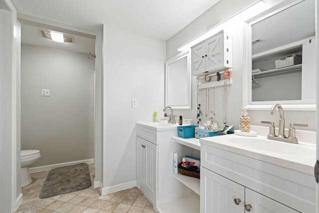 bathroom with a closet, visible vents, and a sink