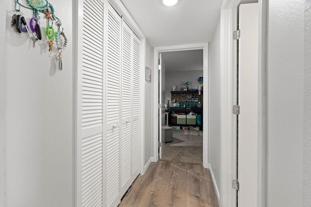 hall featuring wood finished floors and baseboards