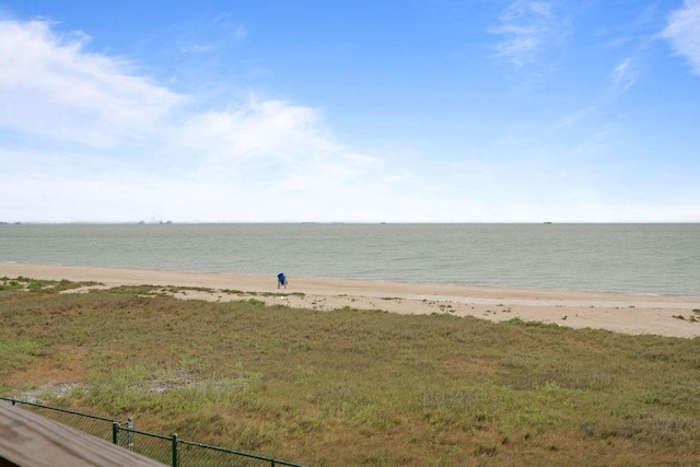 view of water feature featuring fence and a beach view