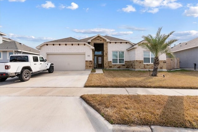 ranch-style home with a garage and a front lawn