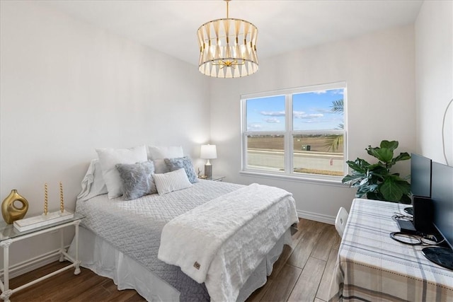 bedroom with dark hardwood / wood-style floors and a notable chandelier