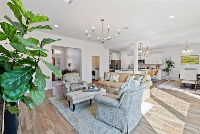 living room featuring light hardwood / wood-style flooring and a notable chandelier