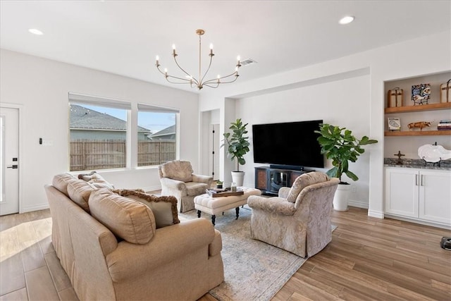 living room featuring an inviting chandelier and light wood-type flooring