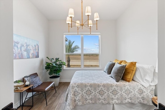 bedroom with hardwood / wood-style floors and a notable chandelier