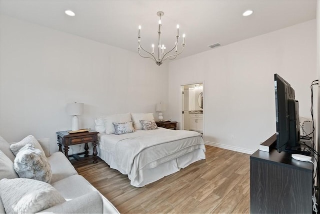 bedroom with a chandelier and light hardwood / wood-style floors