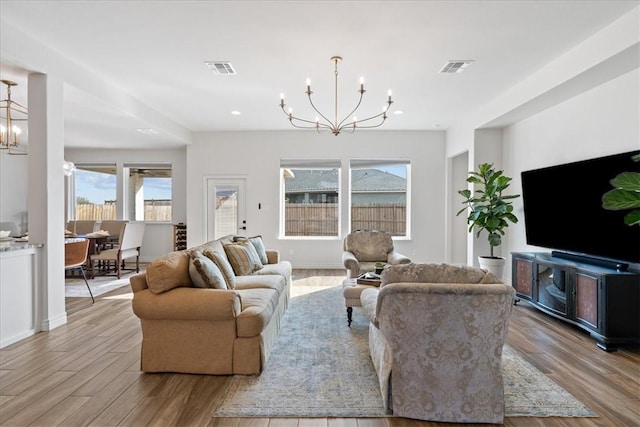 living room with an inviting chandelier and light wood-type flooring