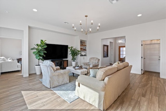 living room with light hardwood / wood-style flooring and a notable chandelier