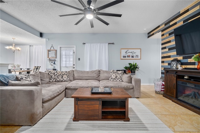 tiled living room with ceiling fan with notable chandelier and a textured ceiling