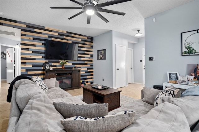 tiled living room featuring ceiling fan and a textured ceiling