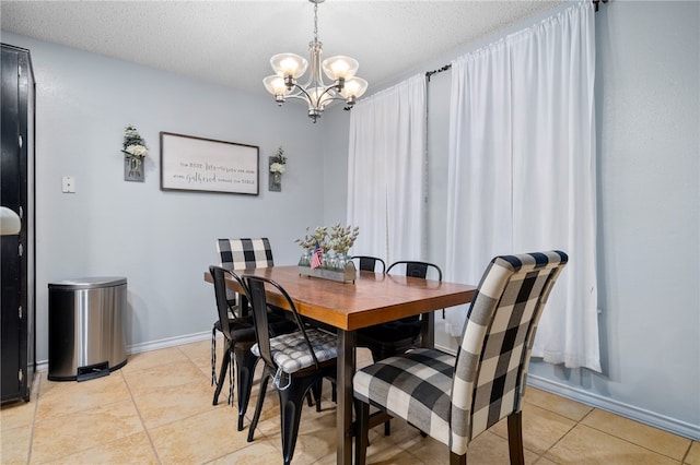 dining space featuring light tile patterned floors, a textured ceiling, and a notable chandelier