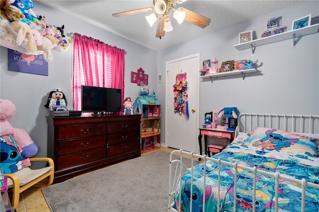 carpeted bedroom with ceiling fan and a textured ceiling