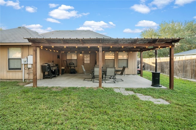 back of property with a lawn and a patio area