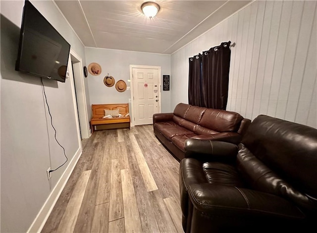 living room featuring wooden walls and light hardwood / wood-style flooring