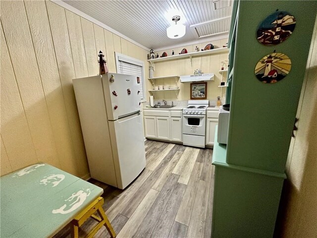 kitchen featuring light wood-type flooring, extractor fan, sink, white cabinets, and white appliances