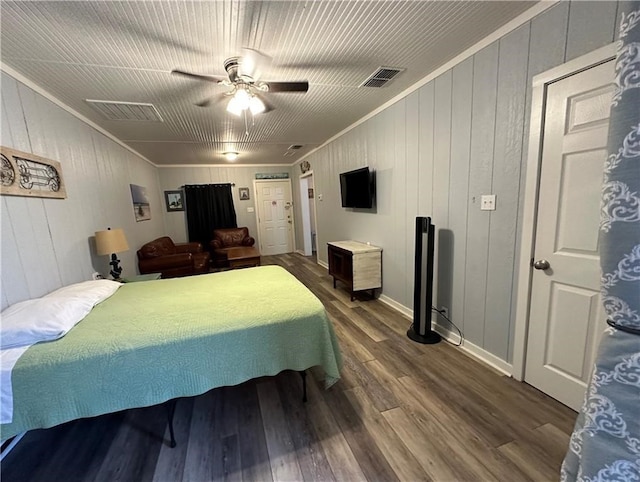 bedroom with hardwood / wood-style floors, ceiling fan, wooden walls, and ornamental molding