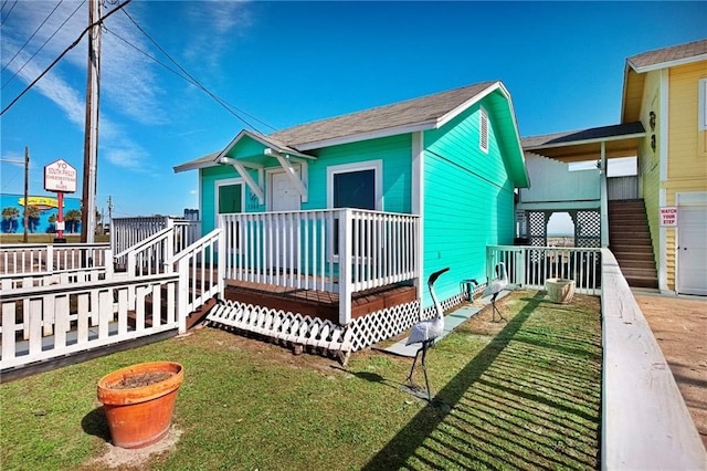 view of front of home featuring a front lawn and a deck