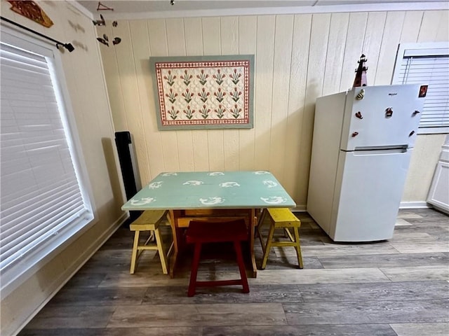 dining area with wooden walls and hardwood / wood-style flooring