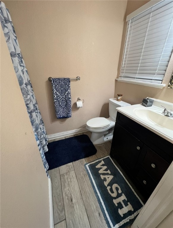 bathroom with vanity, hardwood / wood-style flooring, and toilet