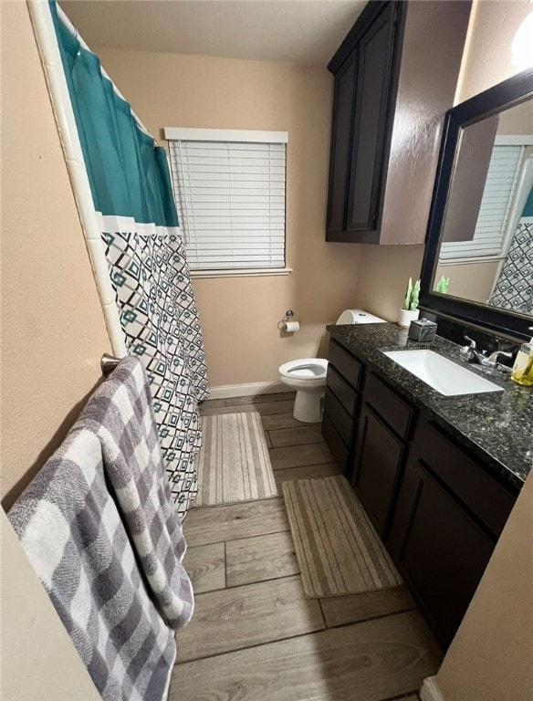 bathroom featuring wood-type flooring, vanity, and toilet