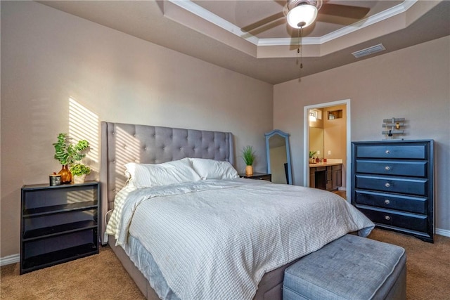 carpeted bedroom with ensuite bath, ornamental molding, and a raised ceiling