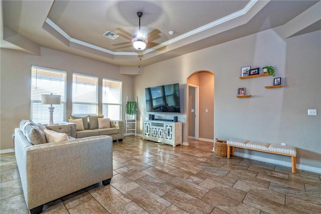 living room with crown molding, ceiling fan, and a tray ceiling