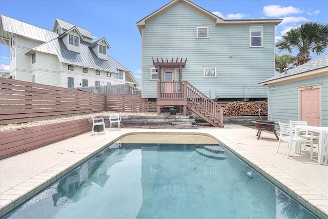 back of property featuring a patio and a fenced in pool