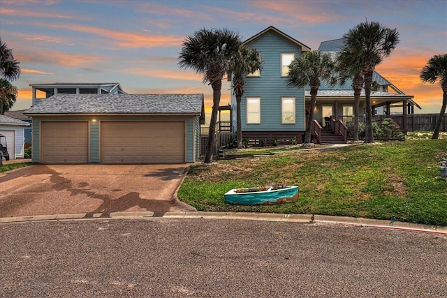 view of front of house featuring a lawn, a porch, and a garage