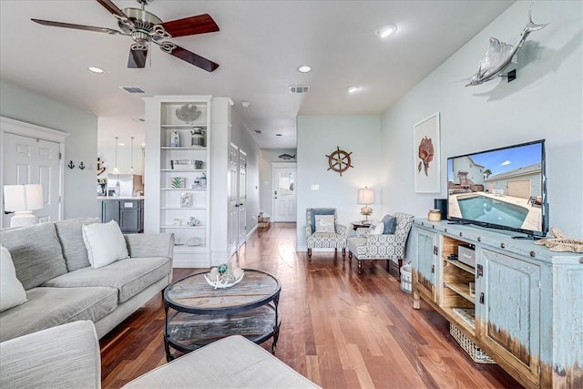 living room with ceiling fan and dark hardwood / wood-style flooring